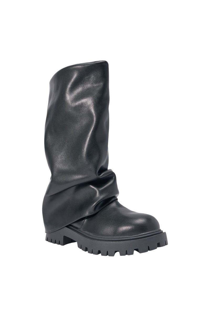 The AZALEA WANG HOYT BLACK FLAT RUCHED BOOTIE features black faux leather, a slouchy ruched shaft, and a chunky platform lug sole, displayed against a white background. 4