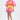 A woman stands wearing a vibrant outfit featuring the Shelby Ombre Mini Skirt and matching blouse, paired with pink heels. The pleated, fan-shaped pink and orange top pops against the plain white background.