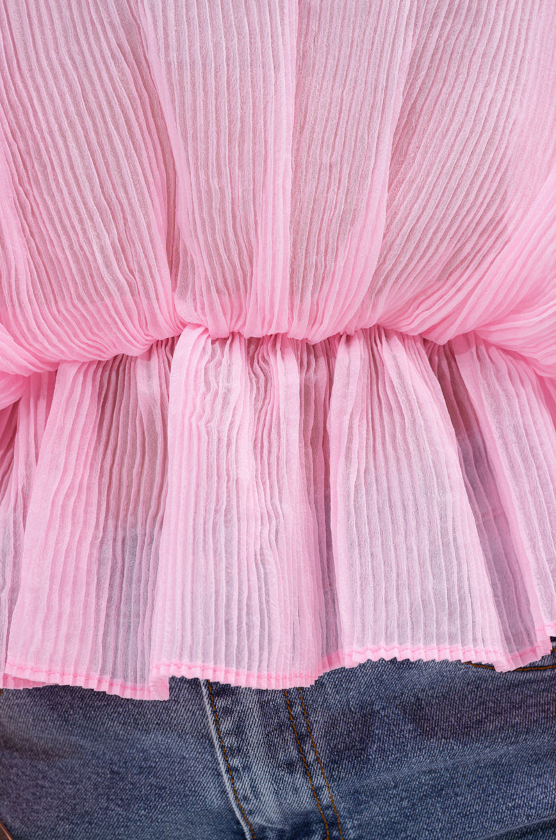 A close-up shows someone in the PRETTY GIRL PROBLEMS BLOUSE, a sheer pleated top with a gathered waist, styled with blue denim jeans.
