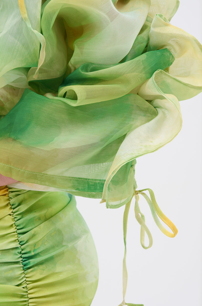 A close-up of the LIMONE CHIFFON BLOUSE shows sheer green and yellow flowing fabric with ruched details, airy layers, a soft watercolor effect, puff sleeves, and a ribbon tie at the edge. 8