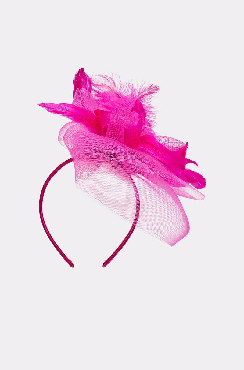 The DERBY DAY PINK FASCINATOR is a bright pink headband with mesh fabric, tulle, and feather accents, shown on a plain light background. 2