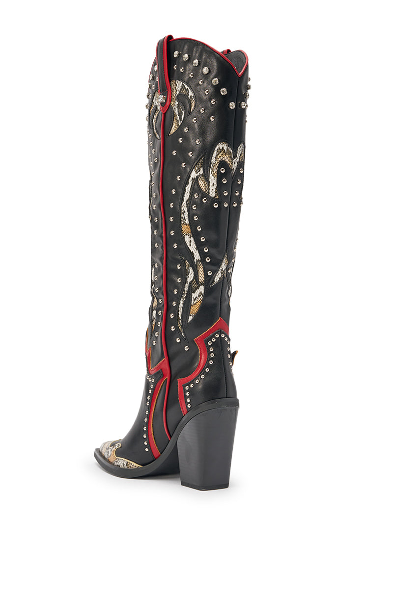 The AZALEA WANG HYPERION BLACK MULTI COLOR WESTERN STUD BOOT features black studded knee-high design, chunky heel, red trim, and detailed gold and silver embroidery, displayed from a rear side angle on a white background. 7