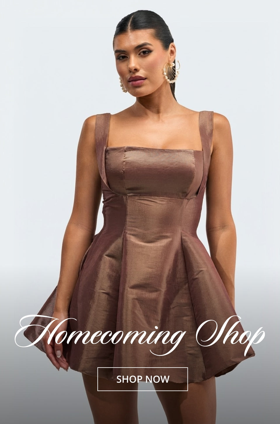 A woman modeling a short, structured brown dress with a flared skirt against a light gray studio background. The image includes the text 'Homecoming Shop' and a 'SHOP NOW' button overlay.