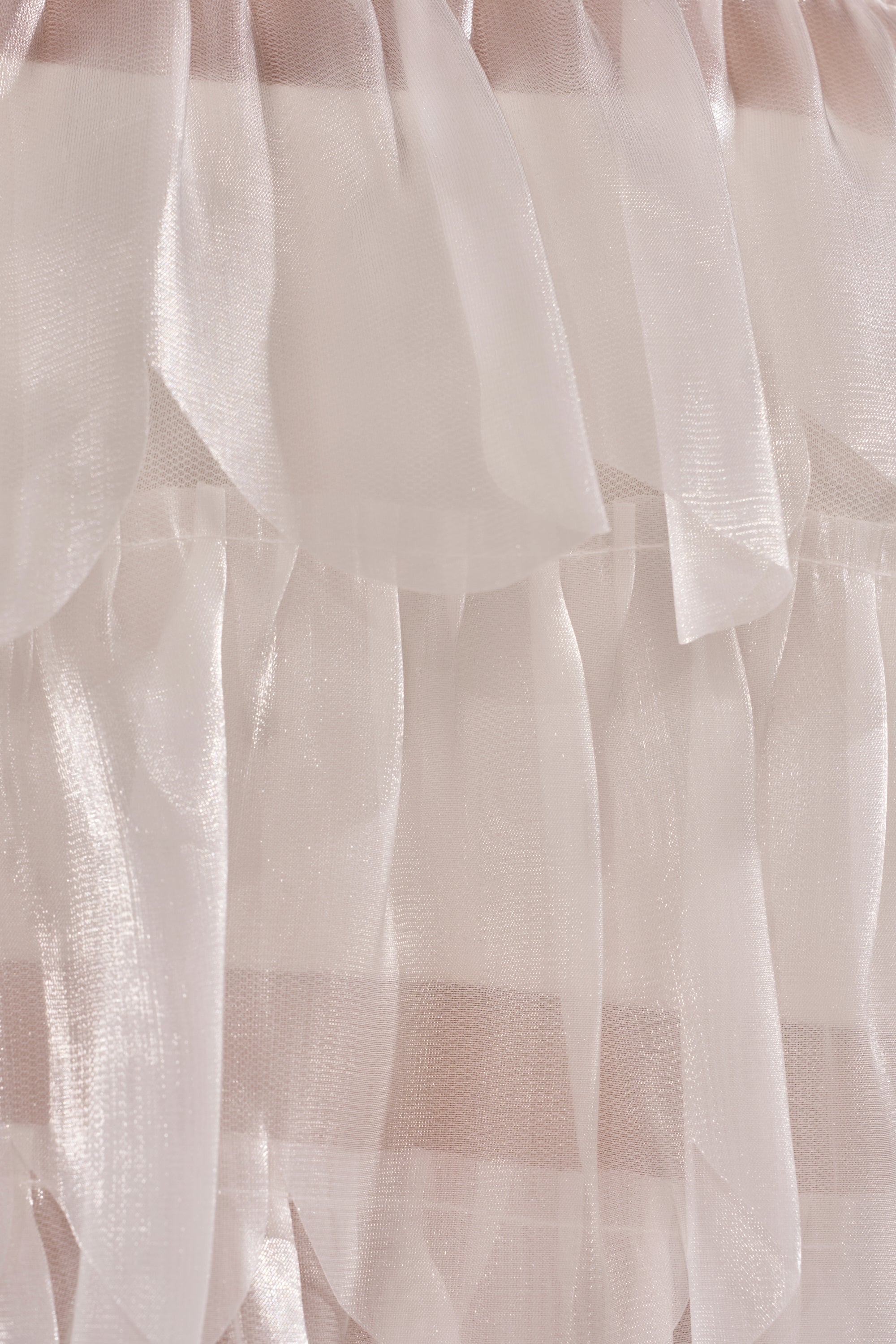 Close-up of the RUFFLE CITY BLOUSE, an elegant women's top made from light pink sheer organza with flowing ruffles and a subtle glossy finish. 8