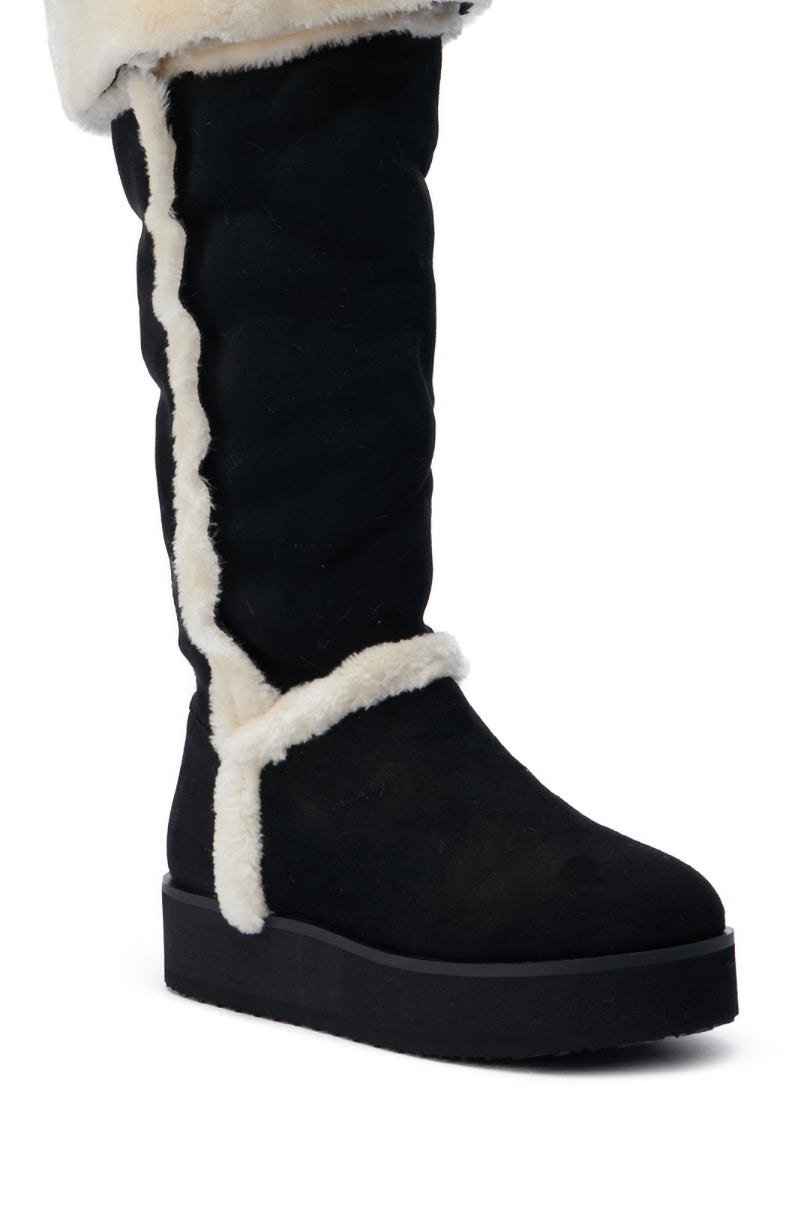 Introducing the AZALEA WANG ICELANDER BLACK FUR BOOT: a chic knee-high design boasting a robust sole. This boot flaunts elegant white fur trim along the front and top edges, crafted from faux suede, offering a warm and stylish solution for cold winter days.