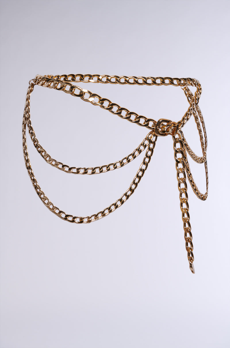 The WESTERN LAYERED CHAIN BELT is a stylish metallic accessory featuring elegantly draped chains. This belt showcases an intricate intertwined design that captivates attention, with polished chain links that beautifully stand out against a plain light background. 3