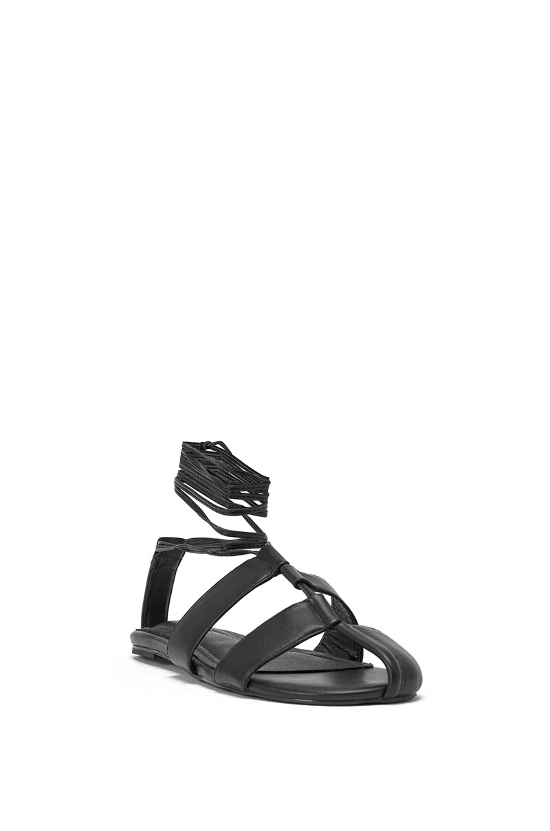 The AZALEA WANG ICHIRO BLACK PEEP TOE FLAT is a black faux leather lace-up sandal with flat soles, open toes, and a high ankle wrap design, shown on a white background. 4