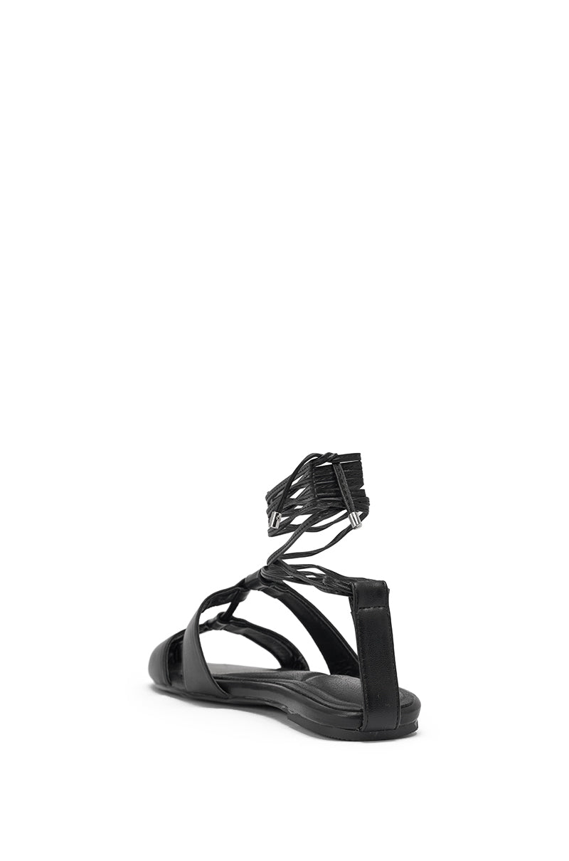 The AZALEA WANG ICHIRO BLACK PEEP TOE FLAT is a black faux leather sandal with wrap-around ankle straps, shown from the back at an angle on a plain white background. 5