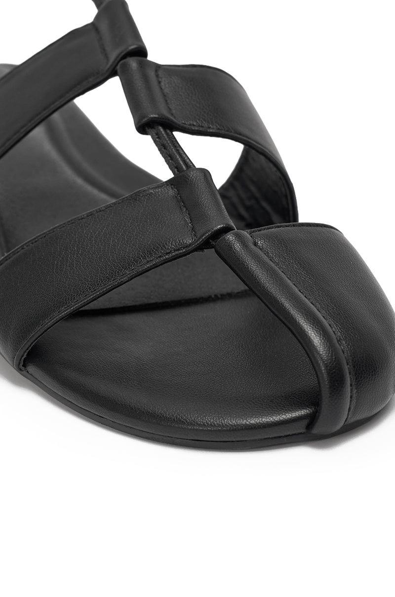 Close-up of the AZALEA WANG ICHIRO BLACK PEEP TOE FLAT, featuring black faux leather, a cushioned footbed, wide crossing straps, lace-up open-toe design, and stylish wraparound ankle ties. 6