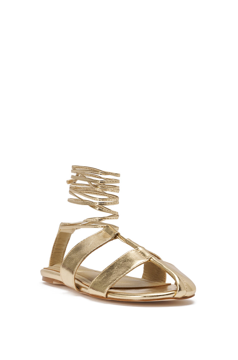 The AZALEA WANG ICHIRO GOLD PEEP TOE FLAT is a metallic gold lace-up sandal with wide foot straps and thin wraparound ankle straps, featuring an open toe and heel plus a comfort cushion insole for stylish all-day wear. 5