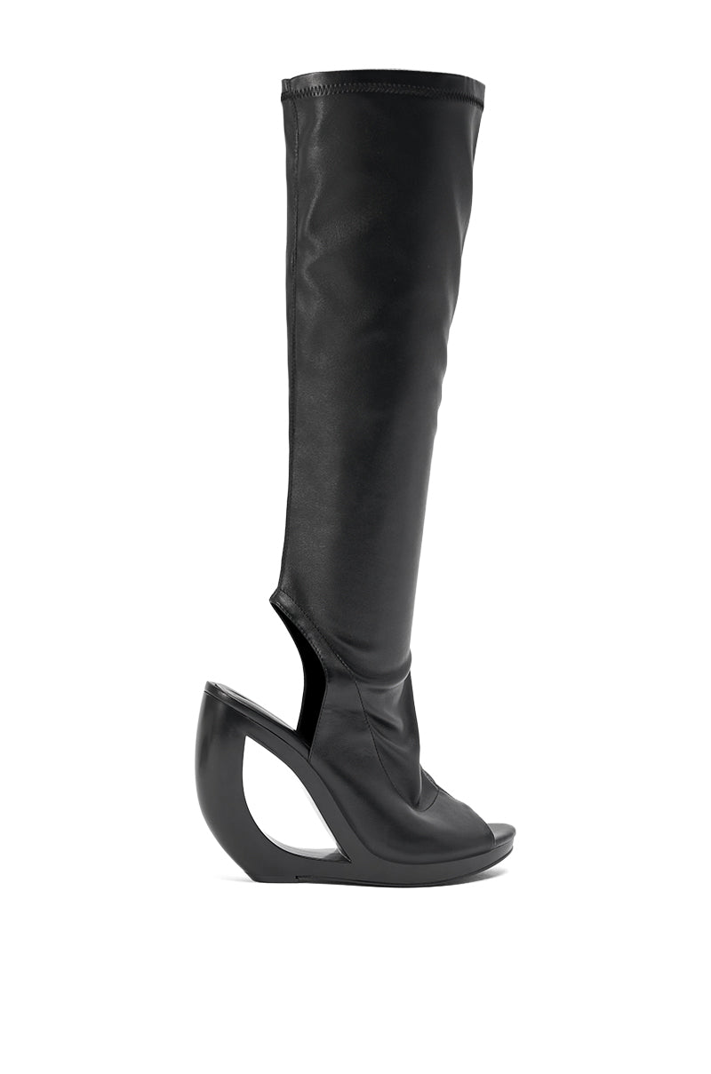 The AZEALA WANG ILYSSA BLACK NOVELTY WEDGE KNEE HIGH BOOTIE is a tall, black, open-toe boot with a striking sculptural cutout wedge heel for a bold, futuristic look. 4