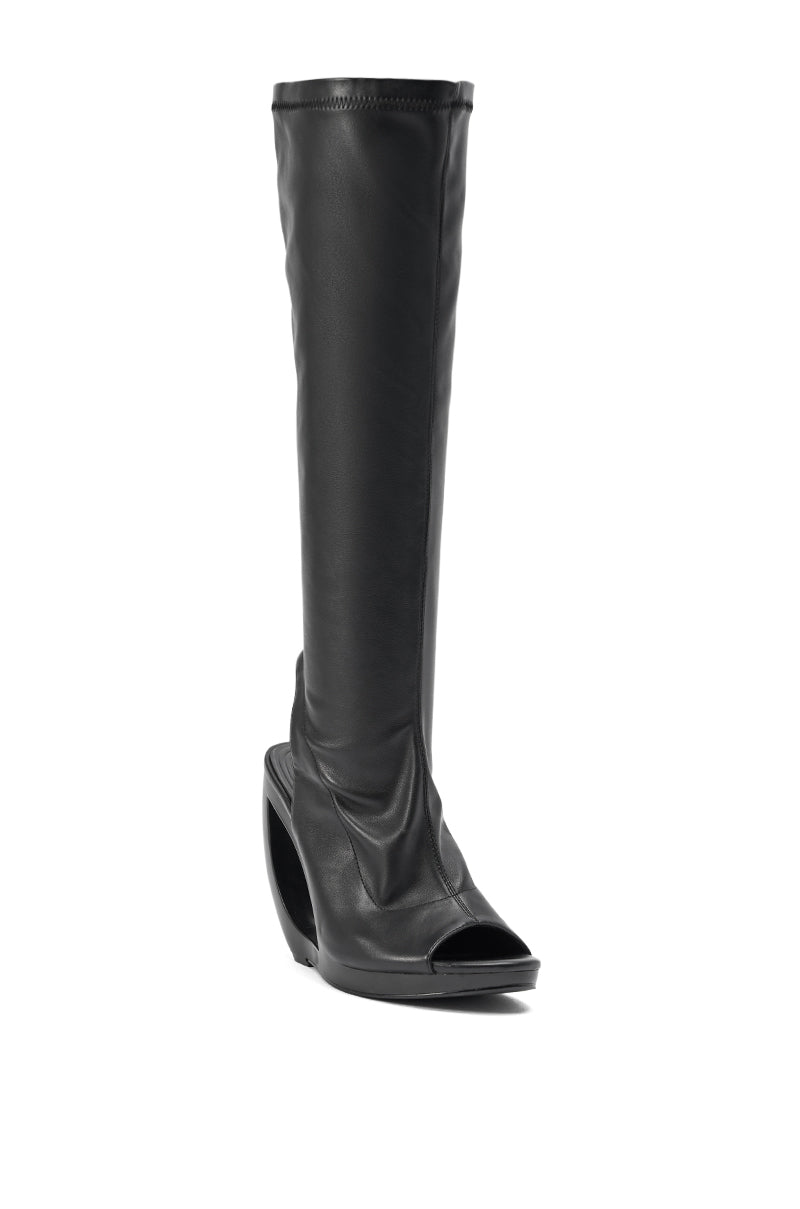 The AZEALA WANG ILYSSA Black Novelty Wedge Knee High Bootie is a single black, open-toe knee-high boot with a large cutout wedge heel, shown against a white background. 5