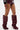 Wearing high-waisted maroon leather shorts, a black sleeve with white and pink text, and the AZALEA WANG IMOGINE BURGUNDY STILETTO SNAP BOOT with pointed toes and silver buttons, a person stands against a white background.