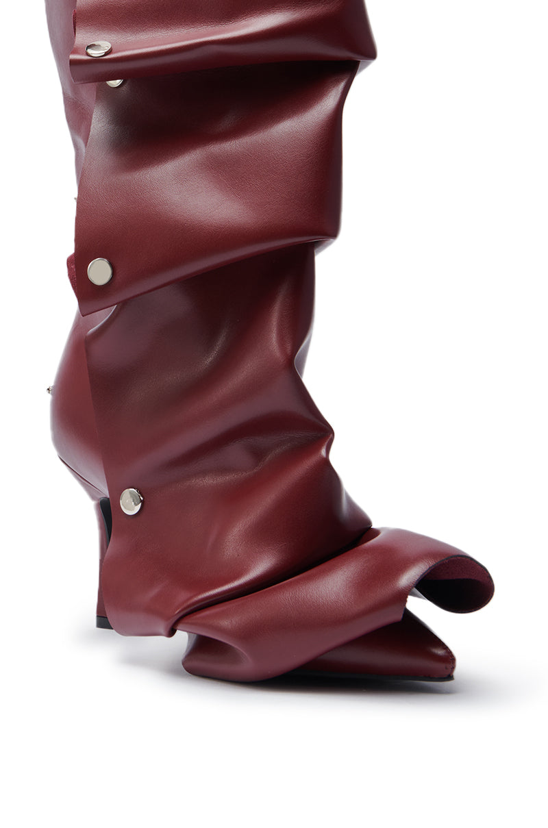 Close-up of the AZALEA WANG IMOGINE BURGUNDY STILETTO SNAP BOOT, featuring shiny faux leather, a unique scrunched and folded design, silver snap buttons, an open toe, and knee-high length against a white background.