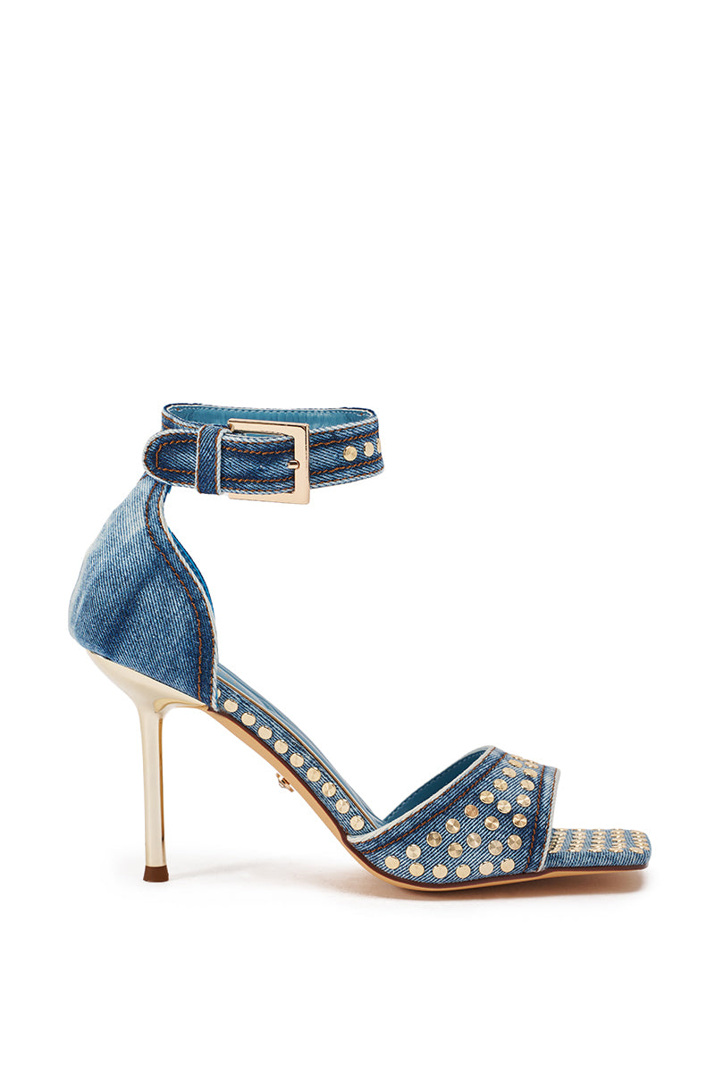 The AKIRA GOLD INANA DENIM STUD EMBELLISHED STILETTO SANDAL features blue denim, gold studs, an ankle strap with a gold buckle, and a slim stiletto heel for a bold statement look. 3