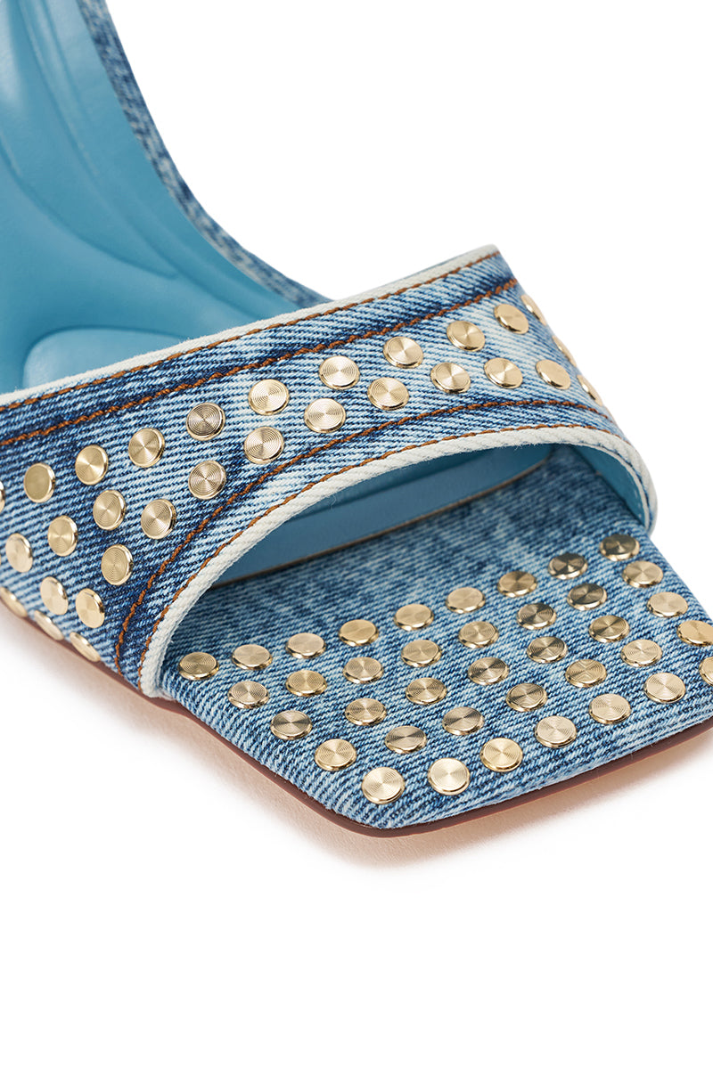 Close-up of the AKIRA GOLD INANA DENIM STUD EMBELLISHED STILETTO SANDAL, featuring blue denim straps with shiny metallic studs, a stiletto heel, and square toe design on a light-colored sole. 6
