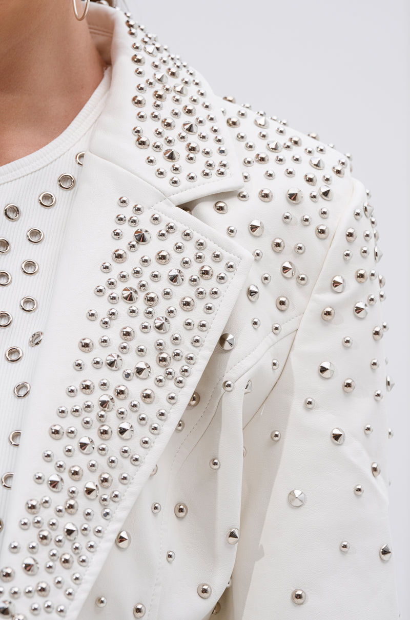 Close-up of the VIVA VEGAS FITTED MOTO JACKET in white, showcasing bold studs and silver spikes, styled over a white ribbed shirt.
