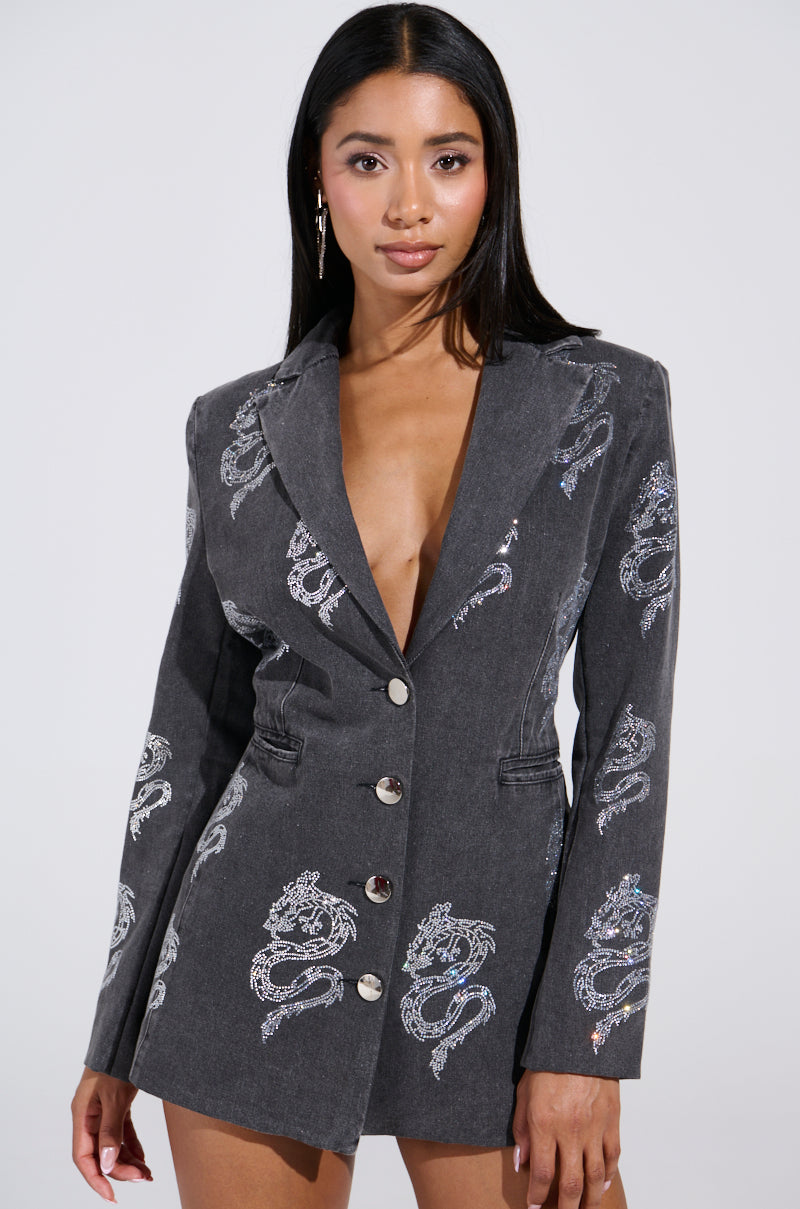A person models the DRAGON SENSE EMBELLISHED BLAZER in dark gray, featuring rhinestone dragon patterns, button detailing, a deep neckline, and long sleeves against a plain background.