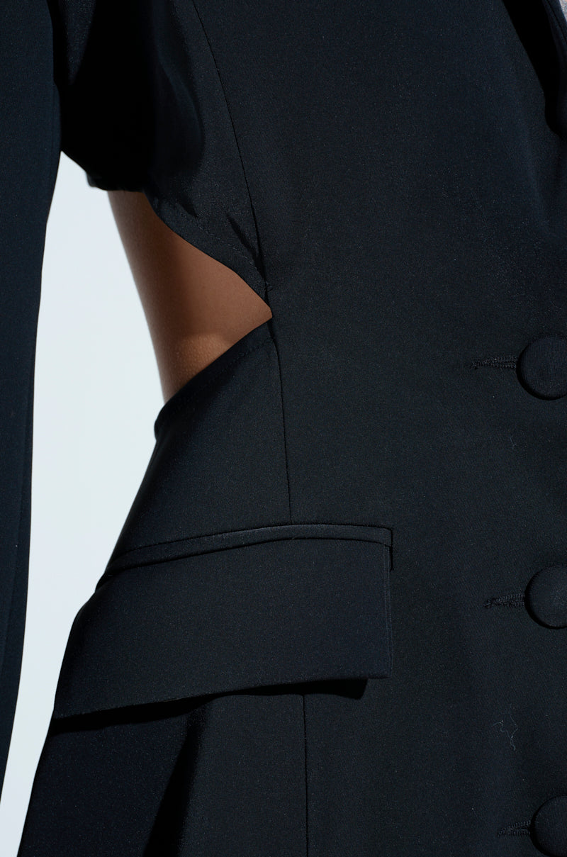 Close-up of a black TAKE A PEEK BLAZER, showcasing a waist cut-out, button accents, and a side flap pocket. This AKIRA Label design highlights elegant modern tailoring with a structured non-stretch silhouette.