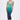 A woman poses against a plain background in the UNDER THE SEA RHINESTONE OMBRE MIDI DRESS, which fades from green to dark blue. She styles it with a high ponytail and green-yellow heels for a striking bodycon look.