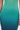 Close-up of a person wearing the UNDER THE SEA RHINESTONE OMBRE MIDI DRESS, featuring a fitted silhouette with sparkling rhinestones fading from green to deep blue. Only the torso and hands are visible.