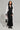 The person exudes a sporty chic vibe, dressed in the DO YOU MIND MAXI DRESS—a hooded black and white zip-up dress with striped sleeves and side details. Paired with black boots and a color-block design bag, they stand confidently against a plain background.