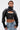 A woman with wet, slicked-back hair confidently wears the NOW YOU SEE ME BOLERO in black faux leather over a black zip-up corset, paired with distressed denim jeans. A 