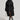 A person wearing the STASSI FITTED PUFFER by AKIRA Label, featuring a metallic front zipper closure, a white furry hat, and knee-high black and white lace-up boots stands against a plain background, holding a small white handbag.