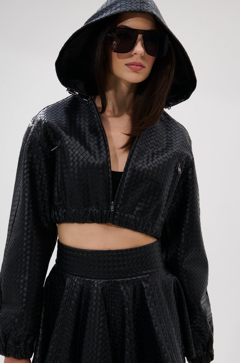 A woman in the KYLIE HOODED BOMBER, styled with a black crop top, high-waisted skirt, and oversized sunglasses, stands against a plain background. 5