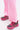 Someone wearing light pink pants and AZALEA WANG ISABEAU FUCHSIA COLOR BLOCKED EMBELLISHED SNEAKERS stands on a white surface.