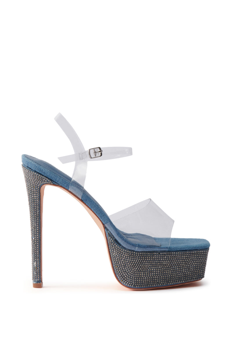 The AZALEA WANG ISAURA Denim Platform Rhinestone Sandal features a high stiletto heel adorned with silver rhinestones, clear PVC straps, a blue sole, and an adjustable ankle buckle.