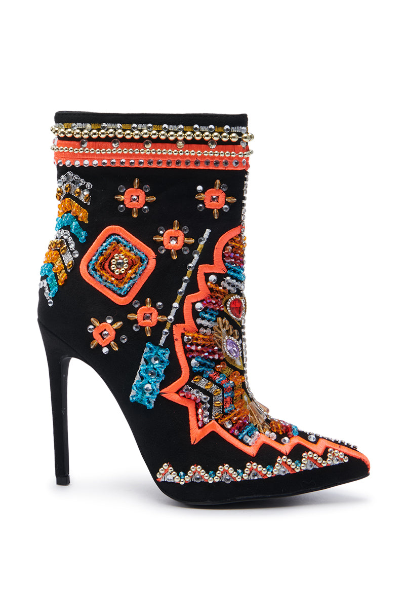 The AZALEA WANG ITSY BITSY MULTI EMBELLISHED BOOTIE is a stunning black stiletto heel, beautifully adorned with intricate multicolored beading and geometric embroidery. It features bright orange, blue, and yellow accents along with sparkling details.