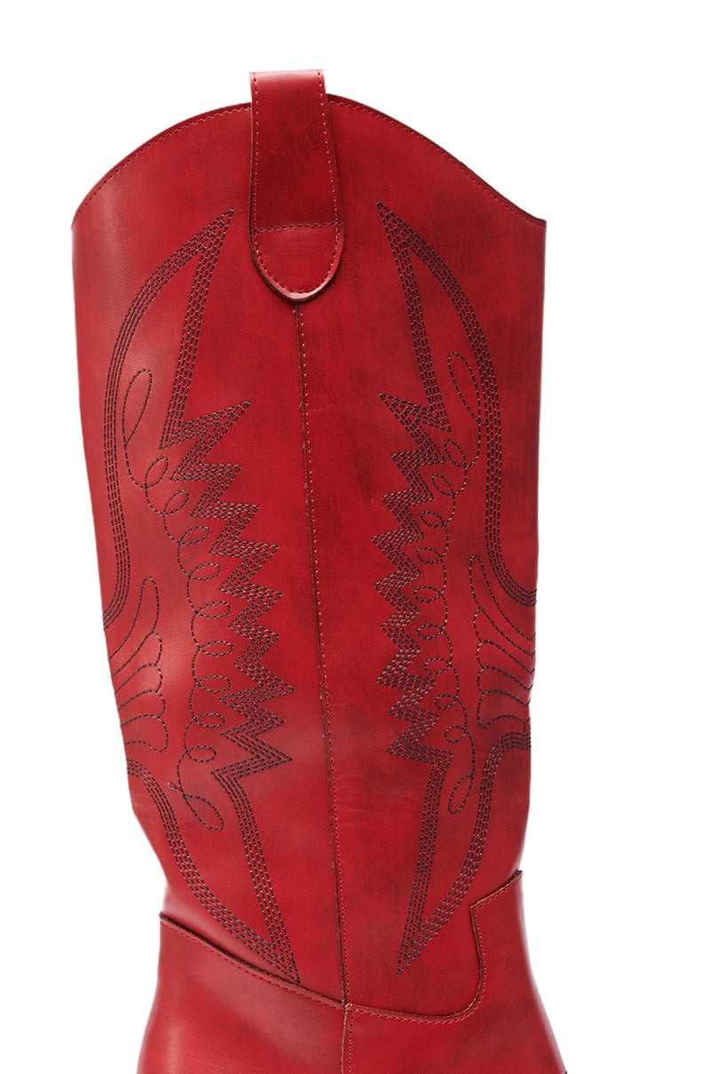 Close-up of the upper part of the IZABELLA WATERMELON WESTERN BOOT in red, featuring decorative black stitching, a pull strap at the top, and crafted from faux leather.