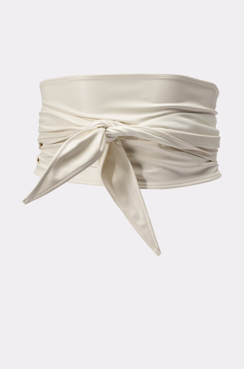 The ULTIMATE CINCH PU BELT is a wide, ivory-colored wrap-around accessory in smooth fabric, featuring a front tie knot with two pointed ends against a plain light background—a true statement piece. 2