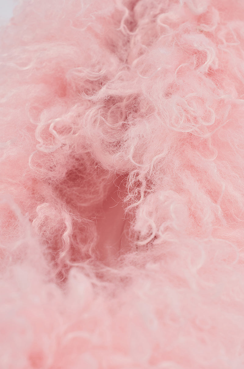 Close-up of soft, curly pink fur with a fluffy texture, inspired by the luxurious material found on the AZALEA WANG JAMEEKA PINK FUR STILETTO PUMP. The airy fur evokes warmth and comfort, filling the frame.