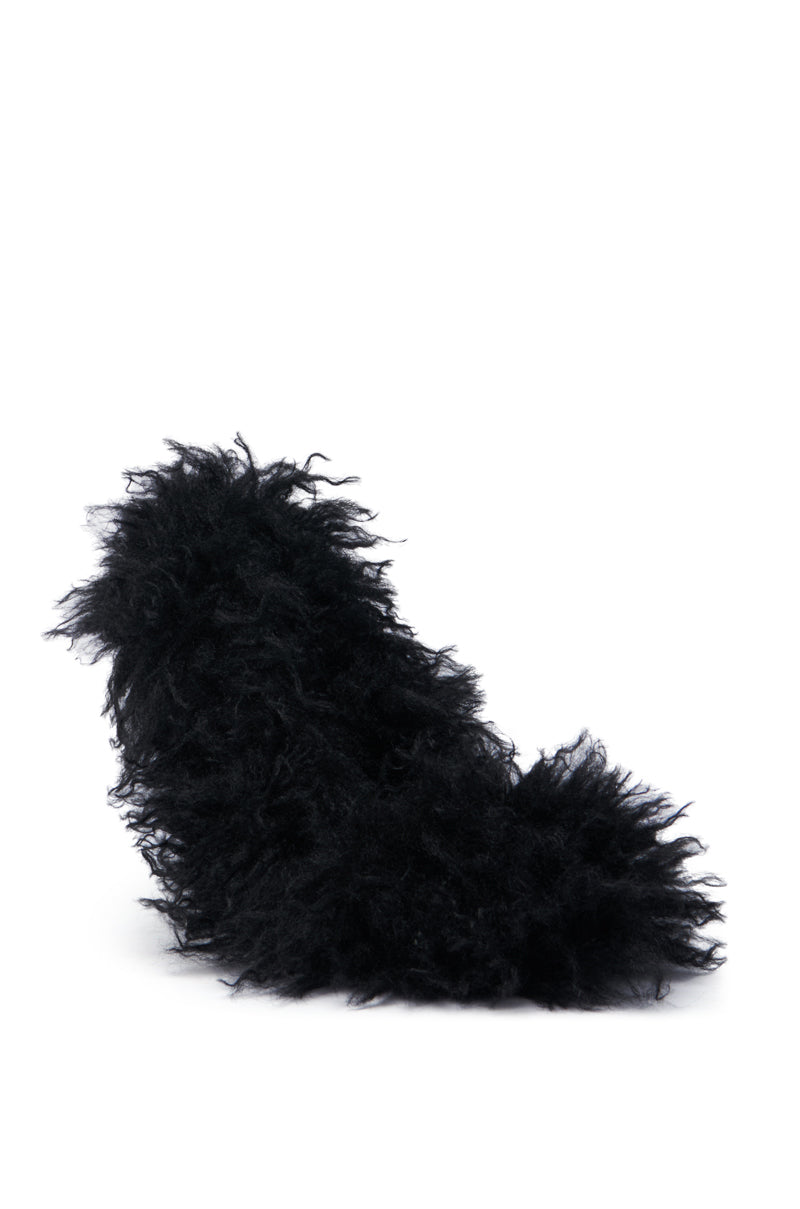 The AZALEA WANG JAMEELA BLACK FUR STILETTO PUMP features a striking, dramatic fluffy texture with a pointed toe. This high-heeled shoe is entirely enveloped in shaggy black faux fur, standing out boldly against a plain white background.