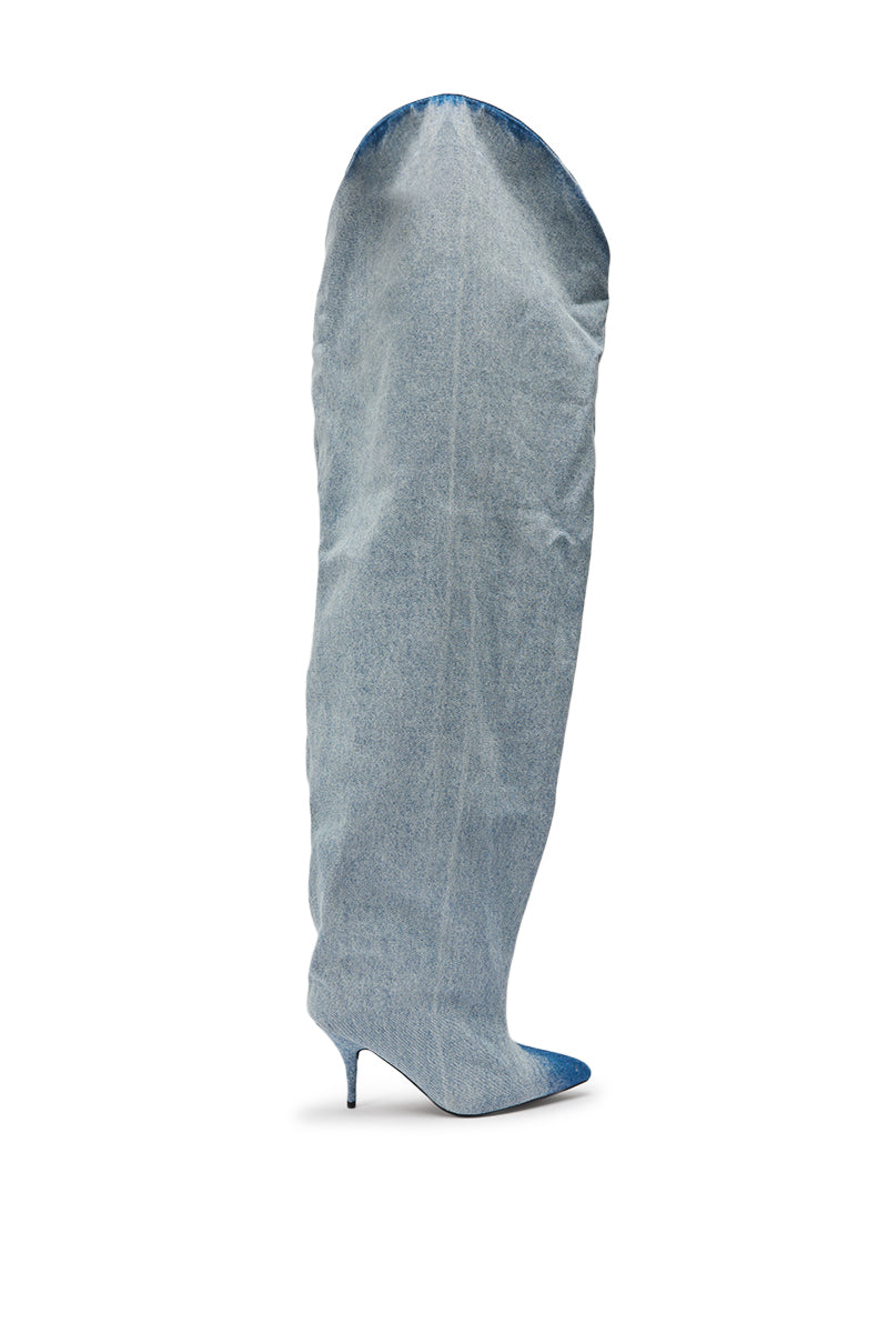 The AKIRA GOLD JANELISSE DENIM STILETTO BOOT is an extra-tall, slouchy, light blue thigh-high denim boot with a pointed toe and stiletto heel, extending well above the knee and photographed on a white background. 3