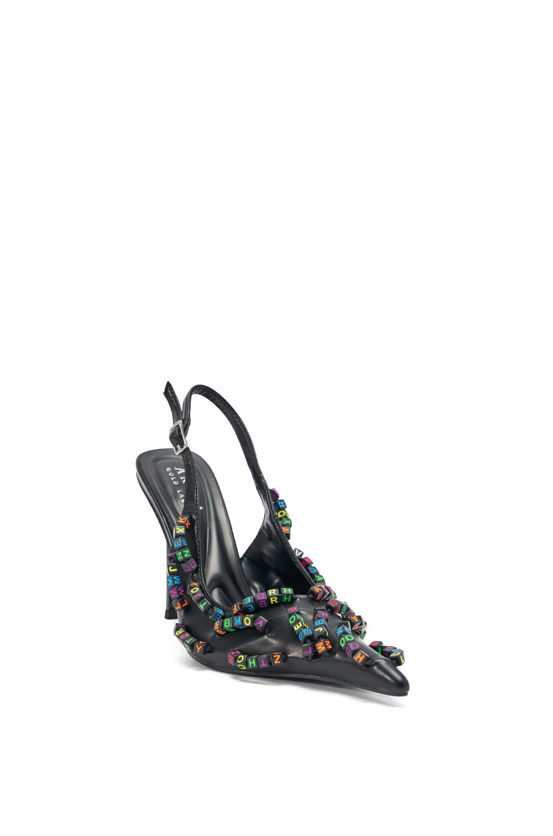 The AKIRA LETTER BEAD EMBELLISHED SLING BACK NOVELTY PUMP is a black pointed-toe sling back with a sleek stiletto heel, decorated with colorful letter bead embellished squares, shown against a white background. 8