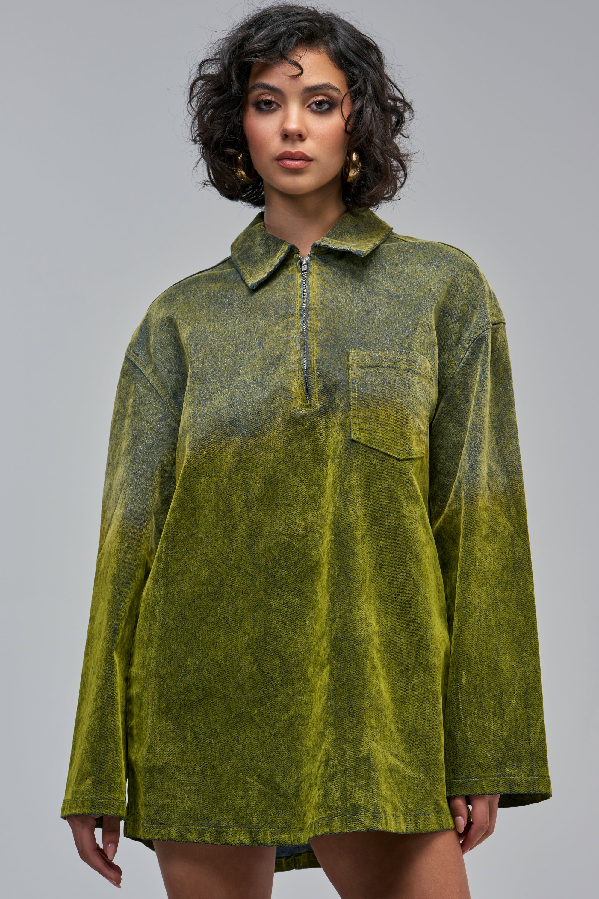 Person wearing a COOL GIRL OVERSIZED VELVET DENIM SHIRT DRESS IN GREEN, featuring an oversized fit and a chest pocket.