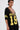 A woman wears large hoop earrings, layered necklaces, and a loose CITY GIRL LAYERED JERSEY MIDI DRESS featuring yellow sleeve stripes, “BROOKLYN 19” on the front, and a deep lace-trimmed V-neckline.