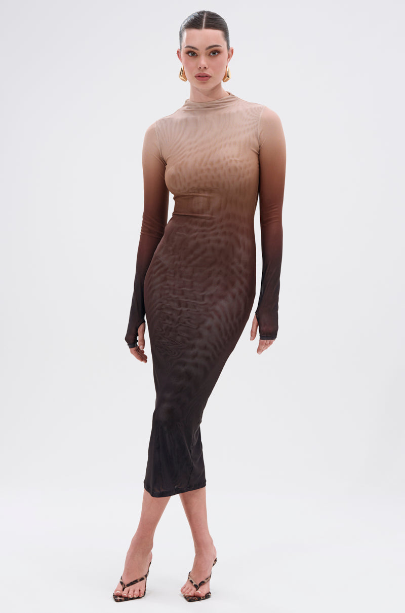 A woman poses against a plain background in the FIFTY SHADES OMBRE MIDI DRESS, a long-sleeved, fitted midi made from sheer mesh that fades from beige to dark brown. She pairs it with black heeled sandals and wears her hair tied back.