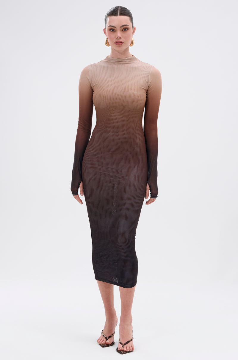 A woman faces forward in the FIFTY SHADES OMBRE MIDI DRESS, a sheer mesh dress that fades from beige to dark brown. Her hair is pulled back, and she accessorizes with hoop earrings and heeled sandals.