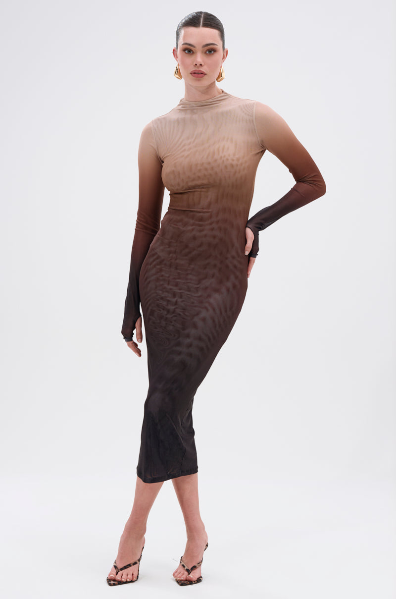 A woman poses confidently in the FIFTY SHADES OMBRE MIDI DRESS—a long-sleeved, sheer mesh dress with an ombre fade from beige to dark brown—styled with heeled sandals and gold earrings against a white background.