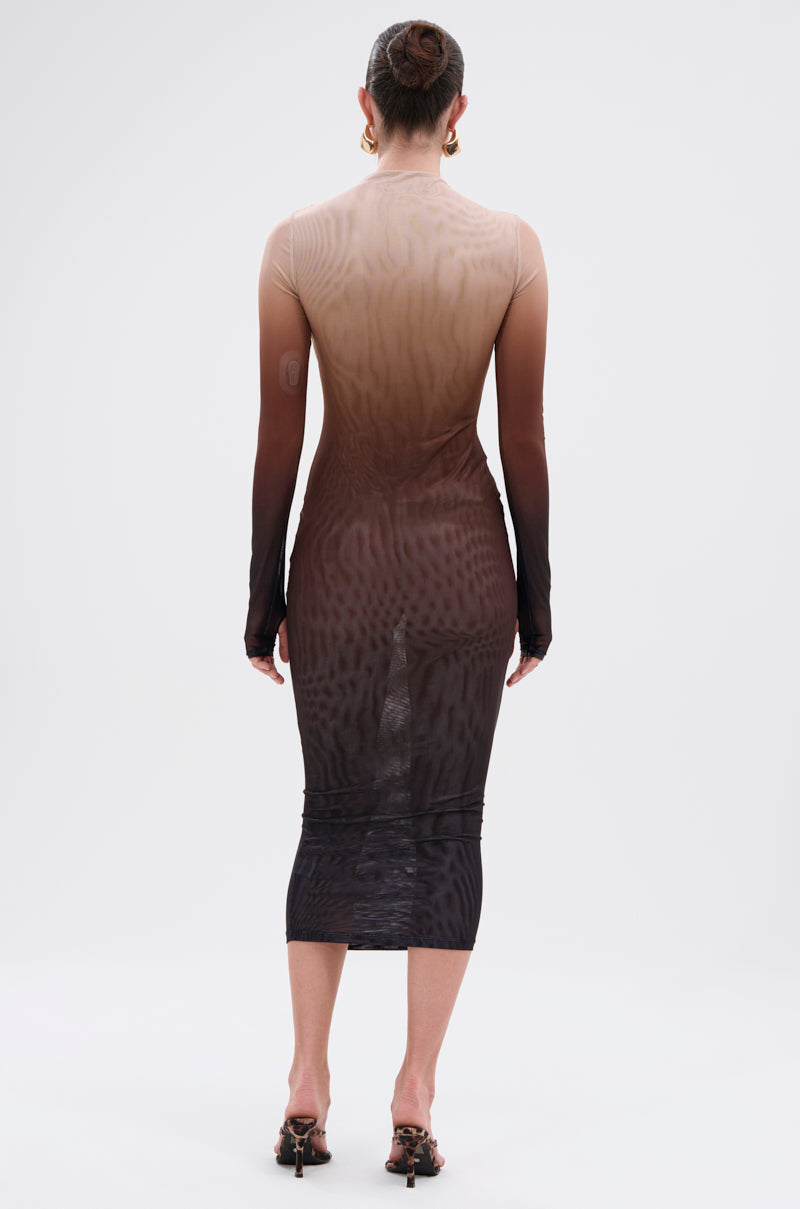 A woman faces away, wearing the FIFTY SHADES OMBRE MIDI DRESS—a fitted, long-sleeve sheer mesh dress that fades from light beige to dark brown—paired with heeled sandals and gold hoop earrings.
