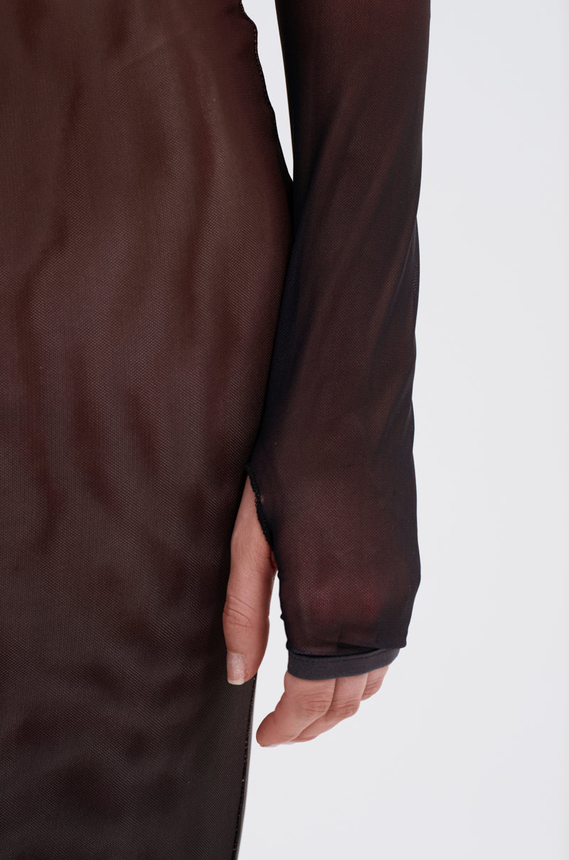 A close-up of a person's arm and hand wearing the FIFTY SHADES OMBRE MIDI DRESS, featuring long-sleeved, sheer black mesh material with the body and sleeve visible against a plain white background.