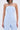 A woman wearing the SUCKER FOR YOU SEERSUCKER JUMPSUIT—light blue and white pinstriped, strapless, with cargo pockets—paired with layered silver chain necklaces.