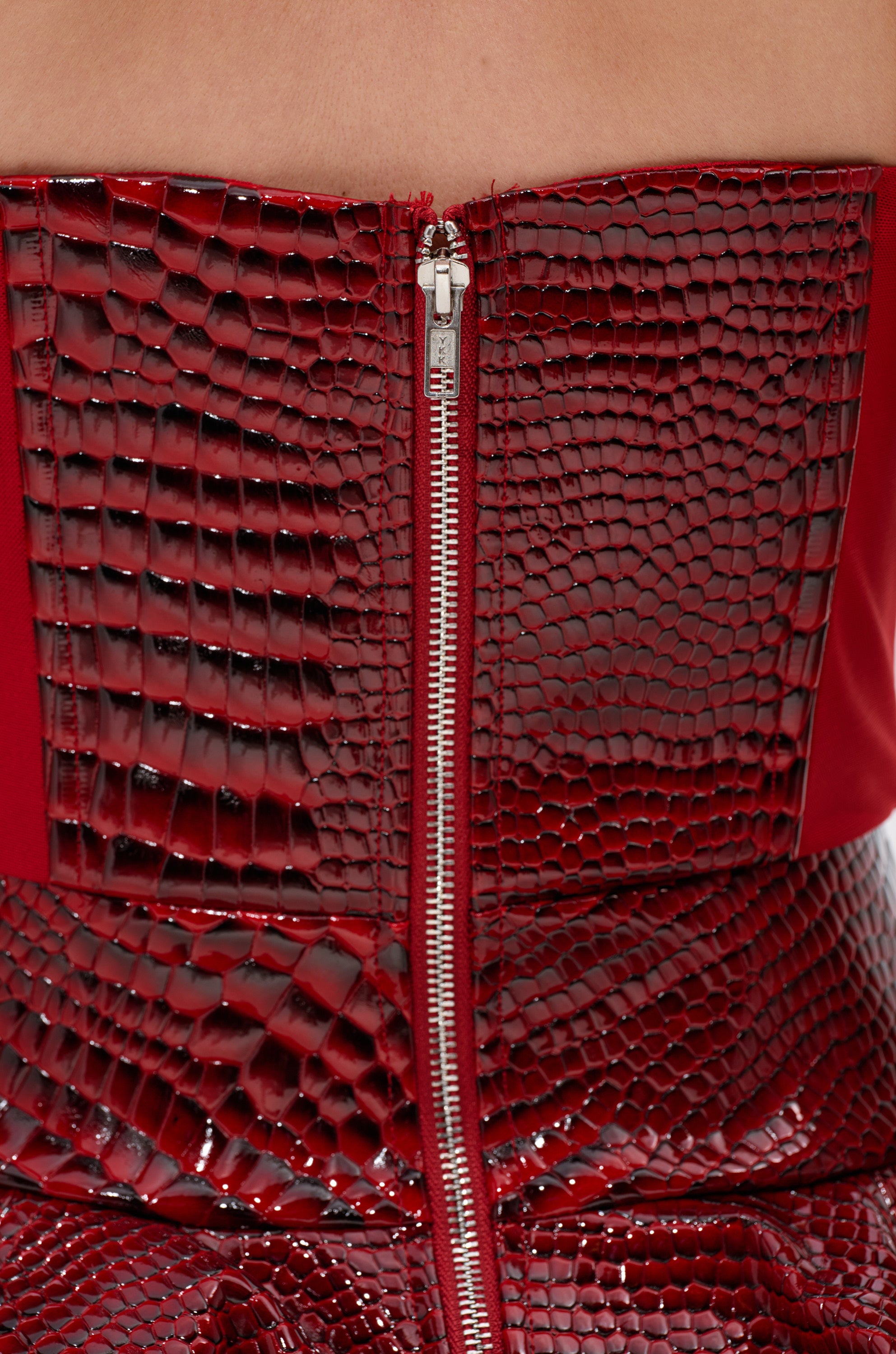 A close-up of the VAL PU MINI DRESS IN CROC PRINT, a strapless mini dress in vibrant red with a structured corset bodice and striking croc print for a bold, elegant look.
