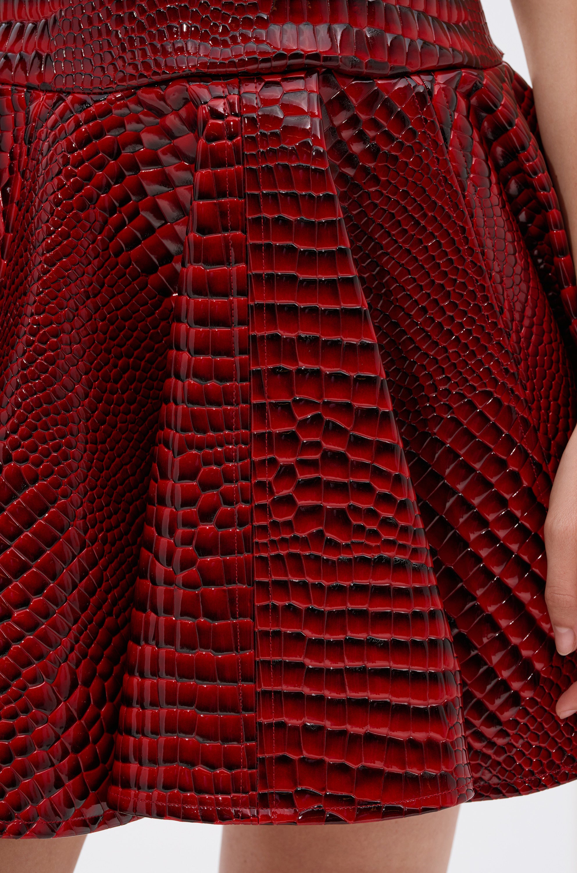 A close-up of the VAL PU MINI DRESS IN CROC PRINT, a strapless mini dress with a corset bodice in vivid red croc-print.