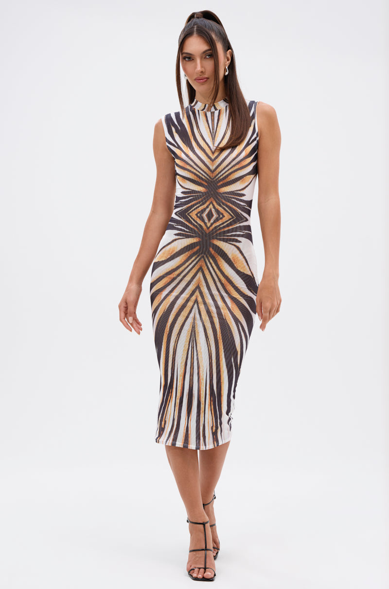A woman models THE BOY'S ALL MINE PRINTED MIDI DRESS, a sleeveless bodycon with a black, brown, and white geometric pattern. She pairs it with black strappy heels and wears her straight hair down against a plain white background. 1