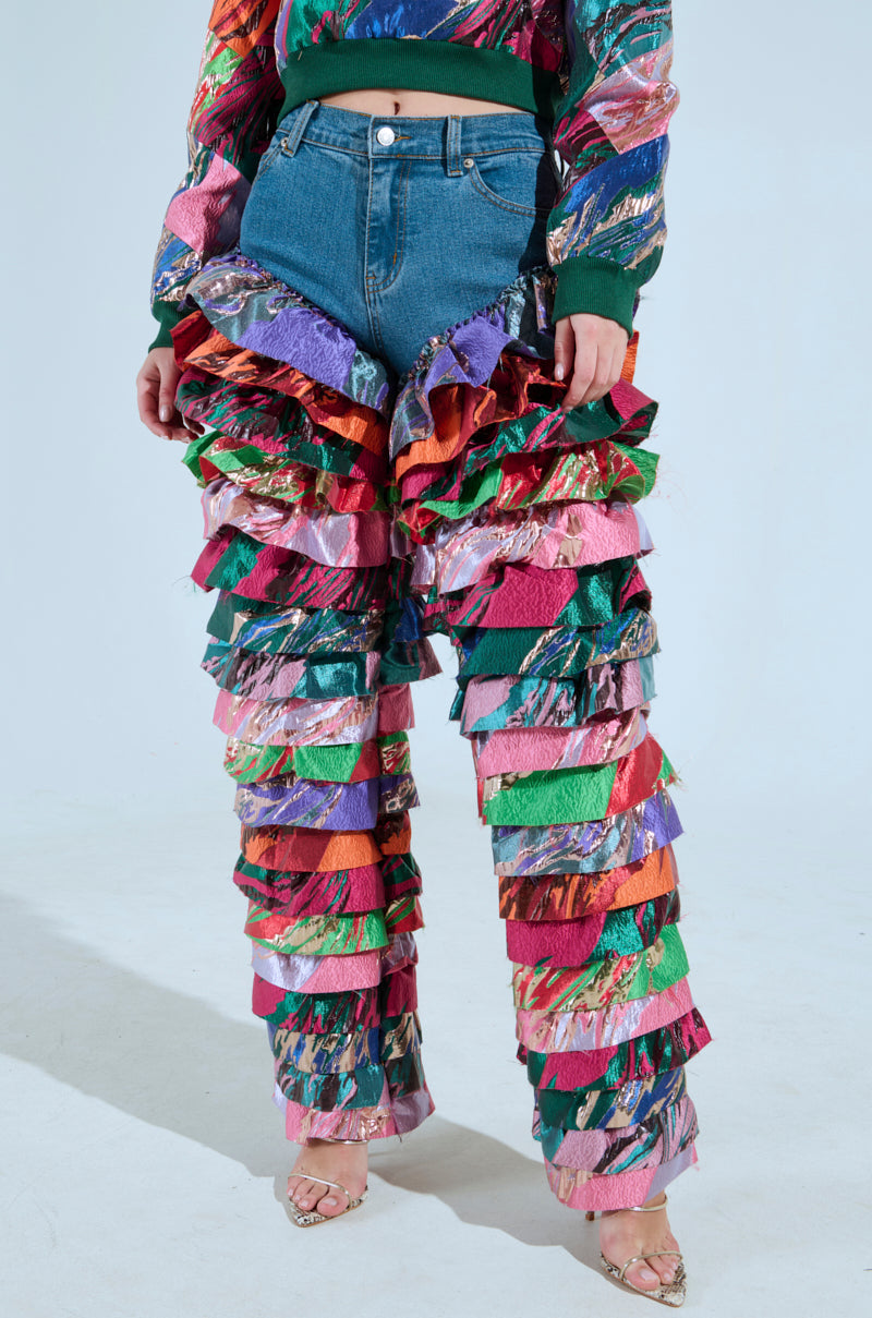 A person in "Life Is But a Dream" brocade ruffle denim pants and matching floral top complements the vibrant ensemble with high-heeled sandals.